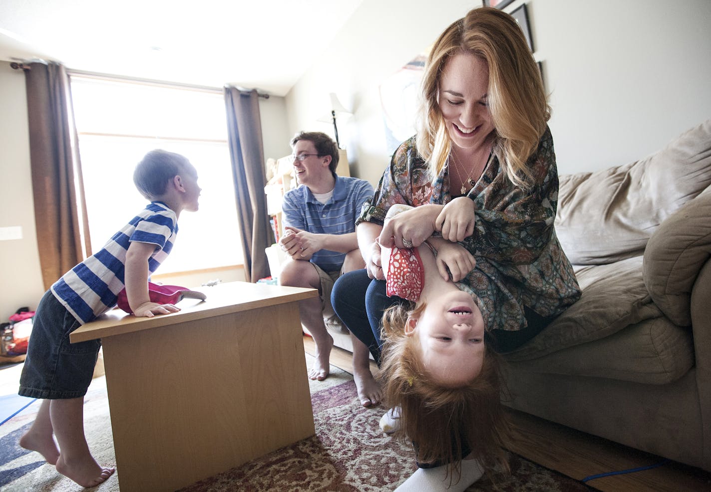 Claire Nielsen and her husband Drew Nielsen play with their children Abbey, 4, and Tyler, 3, at their home in Maple Grove June 9, 2015. Claire carried twins as a gestational surrogate for a California couple and gave birth to them in December. (Courtney Perry/Special to the Star Tribune)