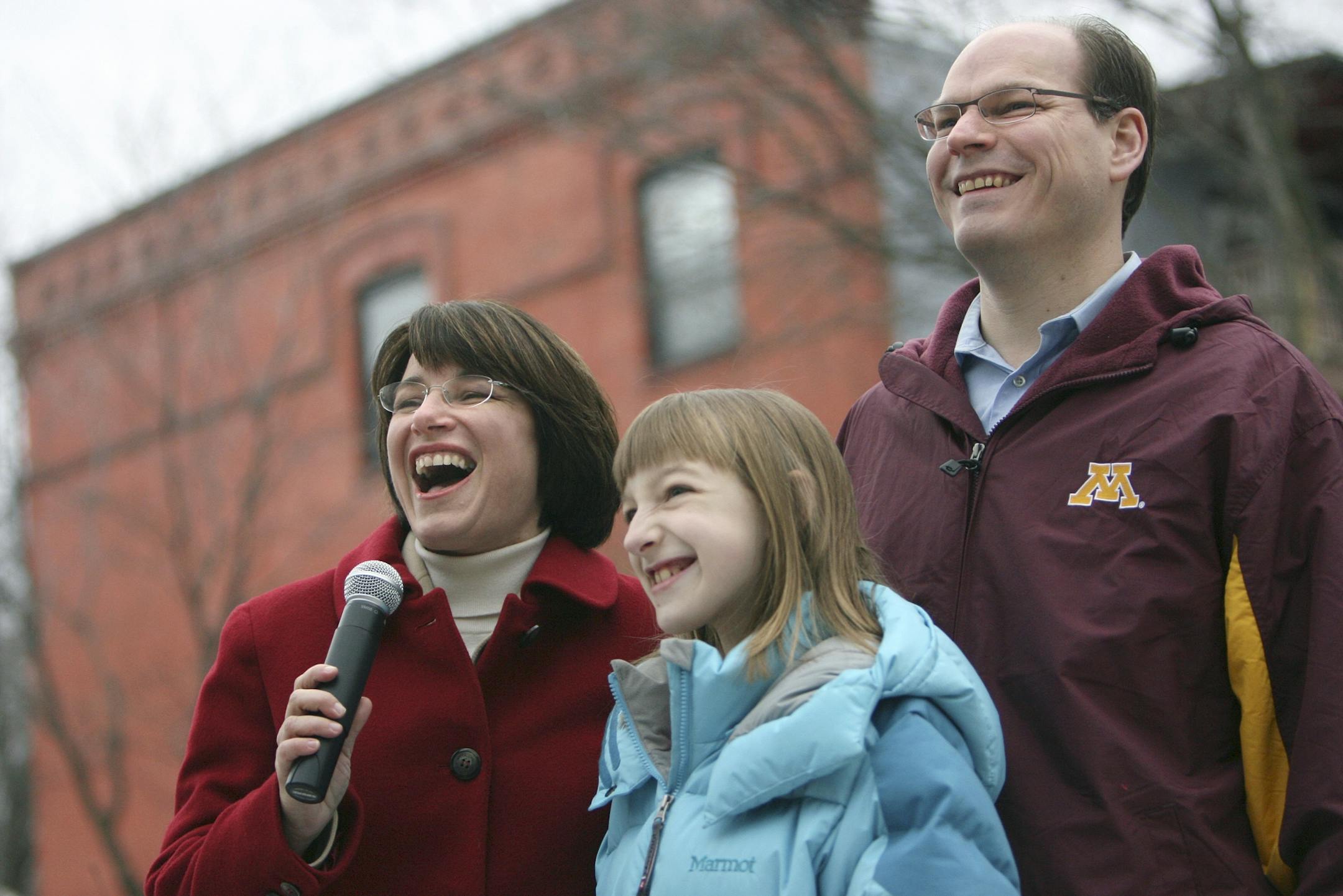 ELIZABETH FLORES ¥ eflores@startribune.com December 27, 2006 - Minneapolis, MN - U.S. Senator-elect Amy Klobuchar, with her husband John and daughter Abigail, says farewell to her family, friends, and supporters from her home in southeast Minneapolis as she makes her way to Washington.