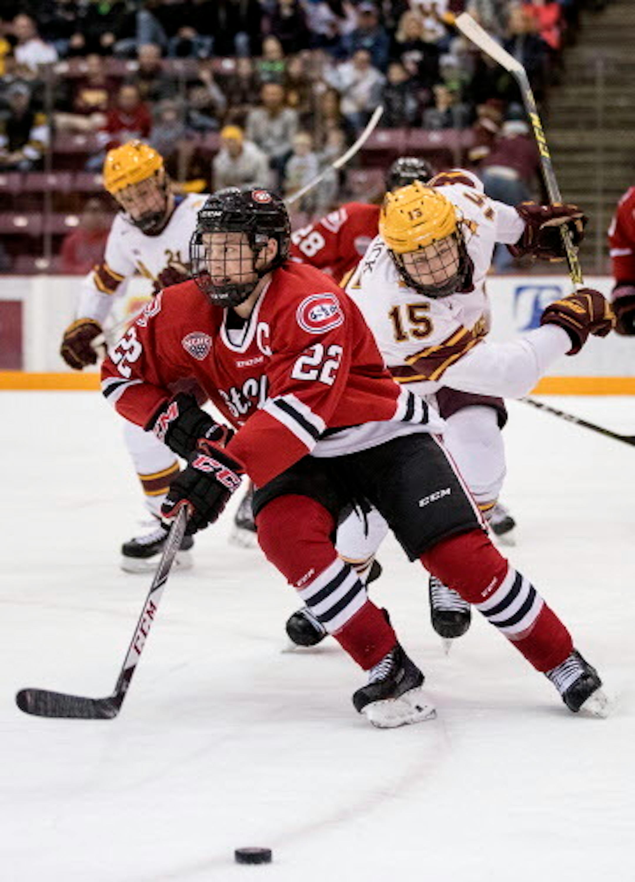 Jimmy Schuldt (22) and Rem Pitlick (15) fought for the puck in the first period.