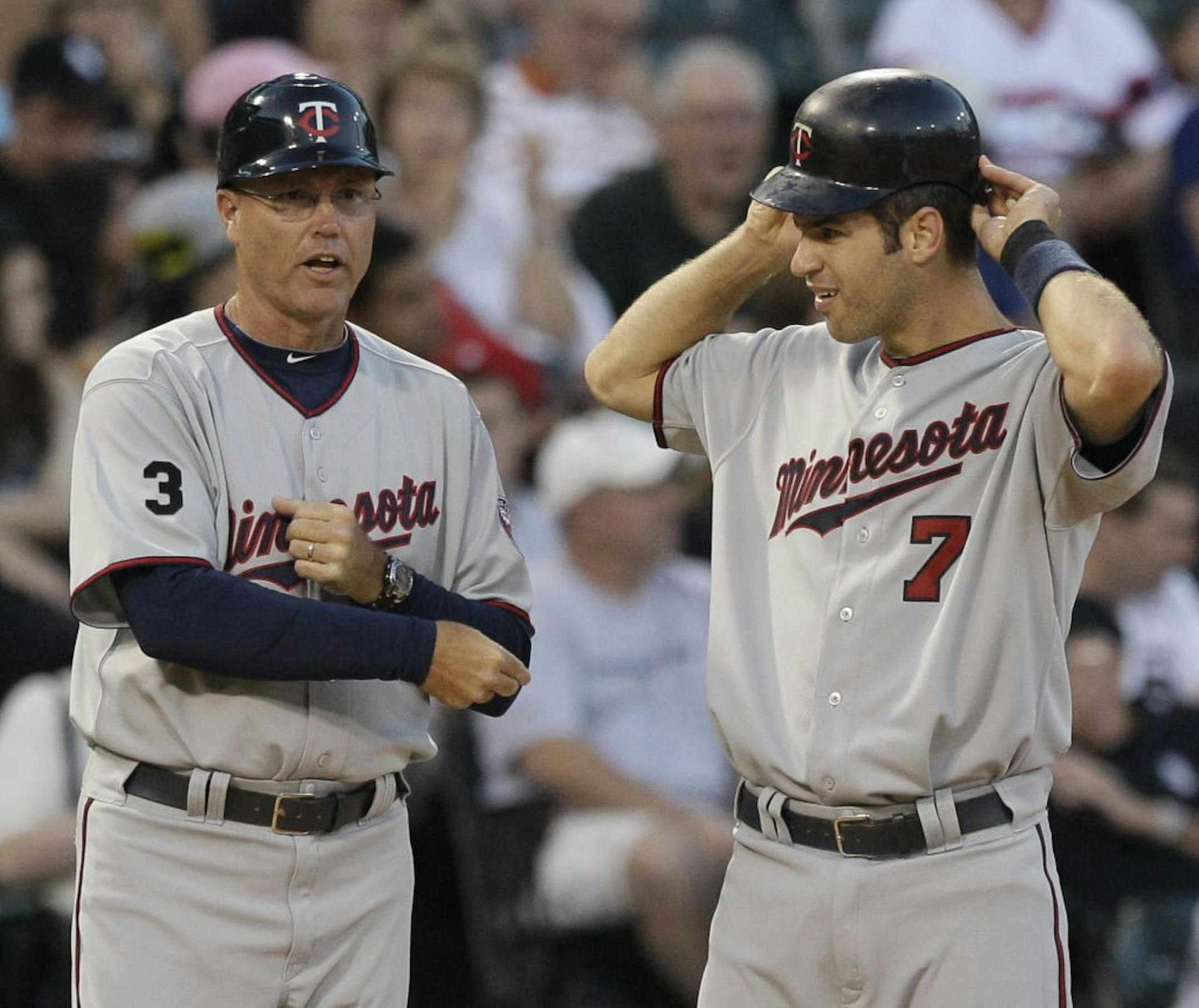 Minnesota Twins third base coach Steve Liddle, left, talks to Joe Mauer at third base during the third inning of a baseball game against the Chicago White Sox Friday, July 8, 2011, in Chicago.