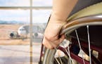 rear view of a man in wheelchair at the airport with focus on hand