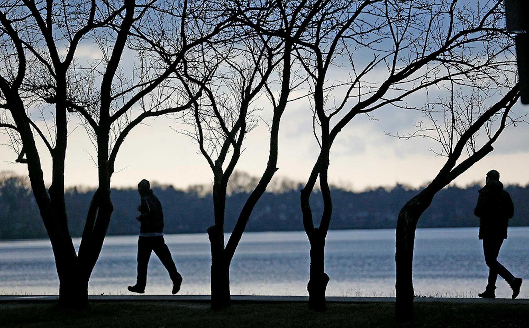 Those long, dark days of winter are fewer with the arrival of the winter solstice. Walkers and runners made their way around Lake Harriet in late November in Minneapolis.