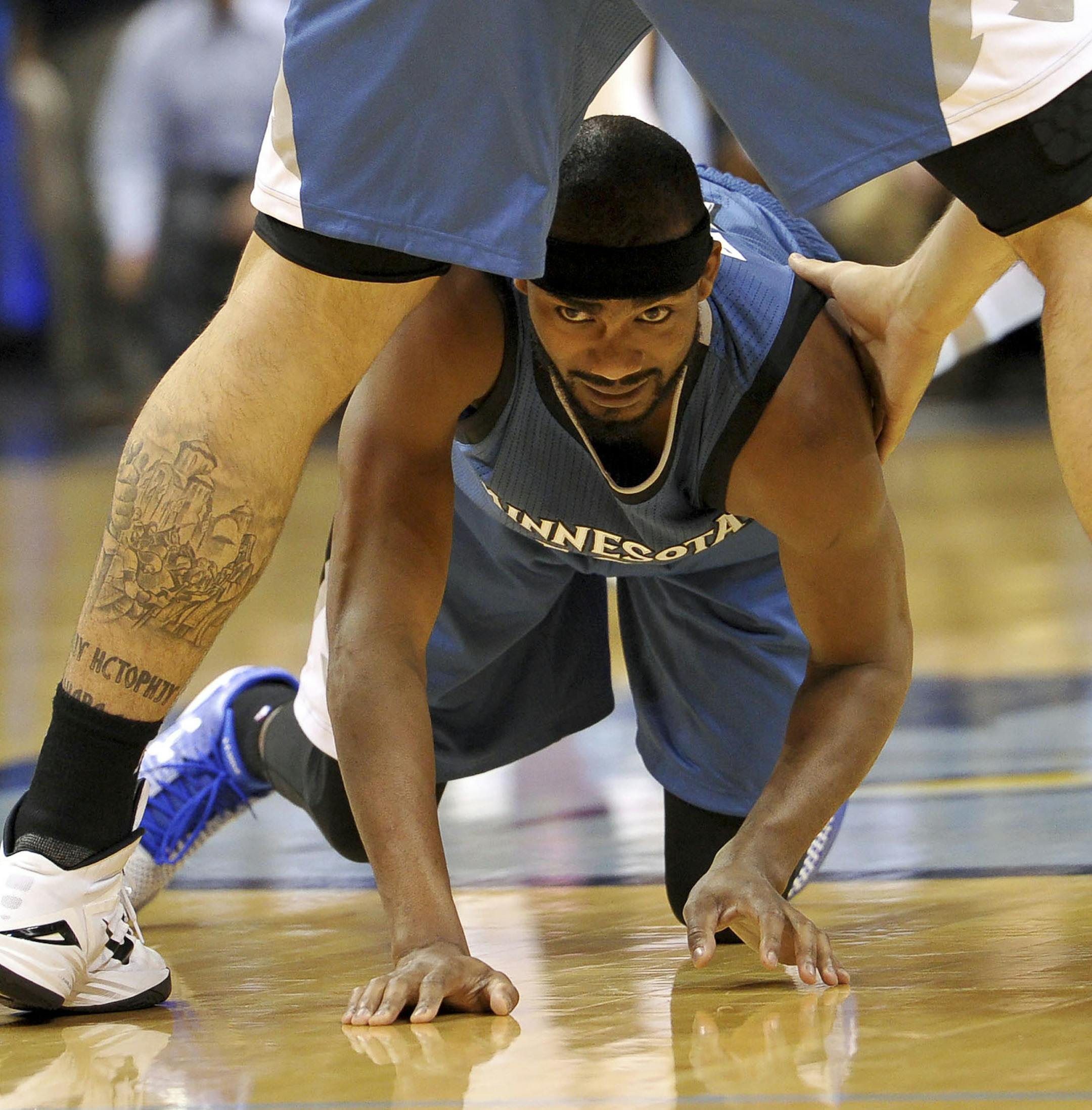 Minnesota Timberwolves forward Corey Brewer is helped up by Timberwolves center Nikola Pekovic in the second half of an NBA basketball game against the Memphis Grizzlies, Wednesday, Oct. 29, 2014, in Memphis, Tenn. (AP Photo/Brandon Dill)