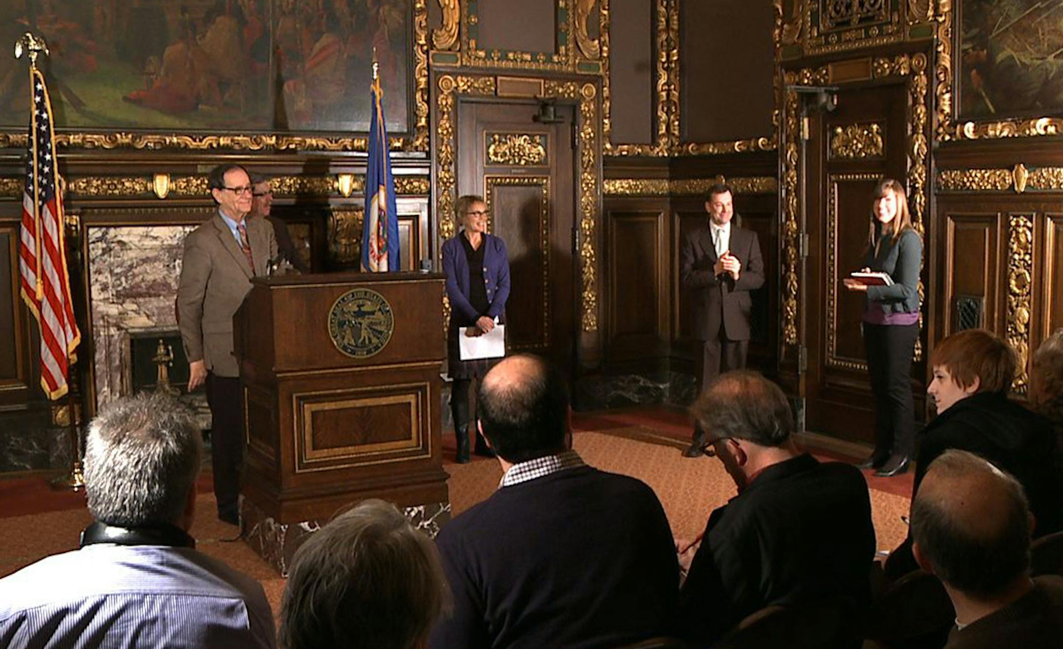 State commissioners and members of Gov. Mark Dayton's staff react after the governor made a quick exit from his press conference.