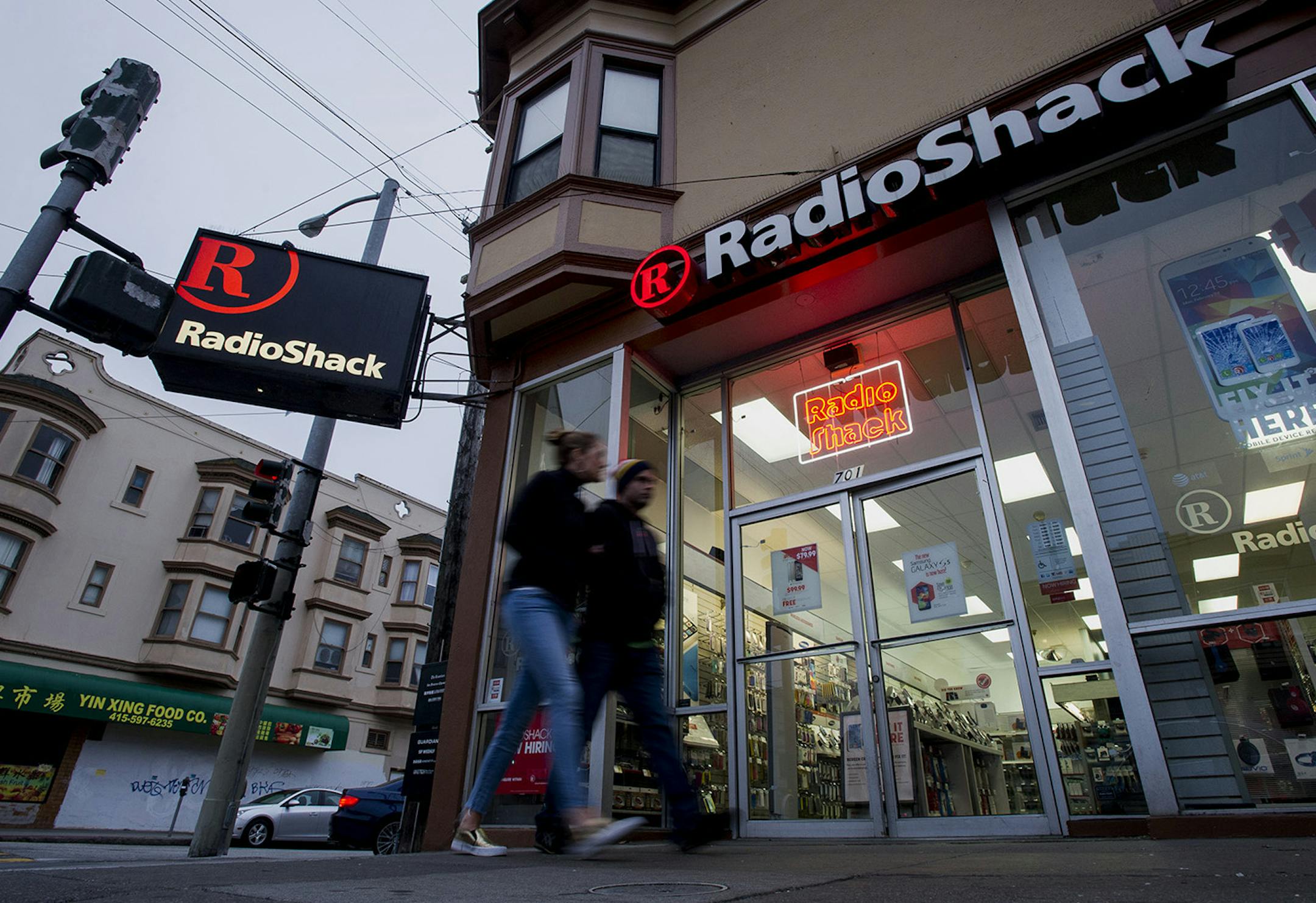 Pedestrians walk past a RadioShack Corp. store in San Francisco, California, U.S., on Saturday, June 7, 2014. RadioShack Corp. is expected to release earnings figures on June 10. Photographer: David Paul Morris/Bloomberg ORG XMIT: 497066767