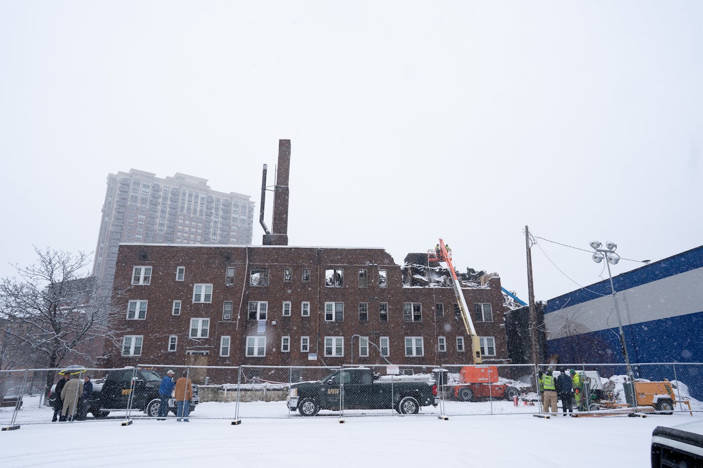 Crews worked though heavy snow on Monday, Dec. 30, slowly knocking down walls abutting a neighboring garage that was undamaged by the Drake Hotel fire on Christmas Day in downtown Minneapolis.