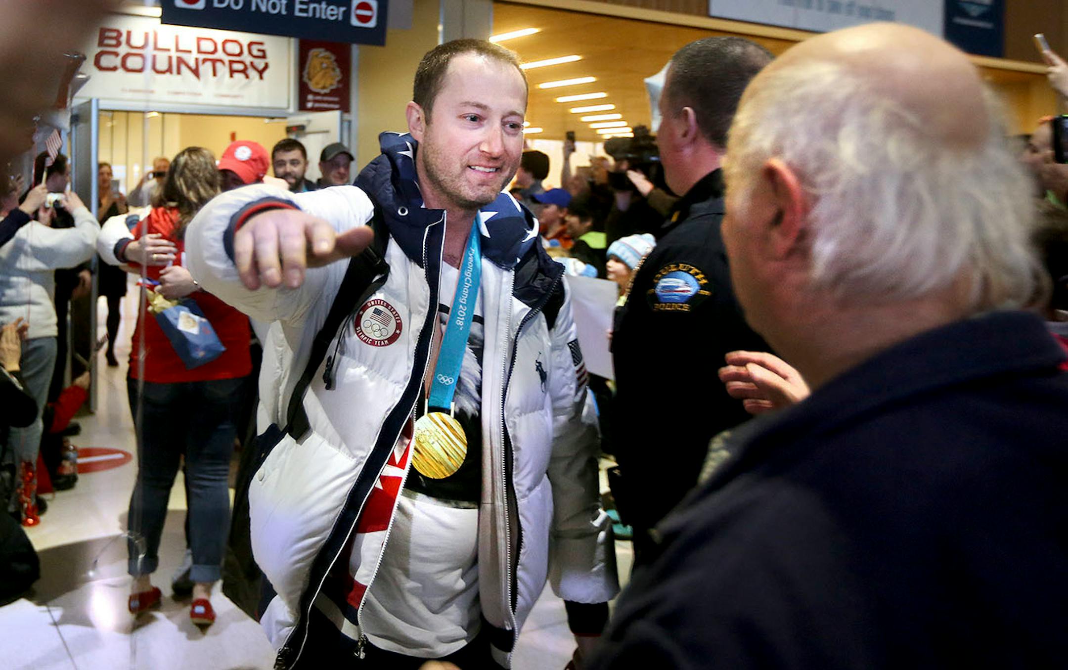 Duluth curling team member Tyler George reaches out to give a hug on his arrival at the airport Monday evening. Bob King / rking@duluthnews.com