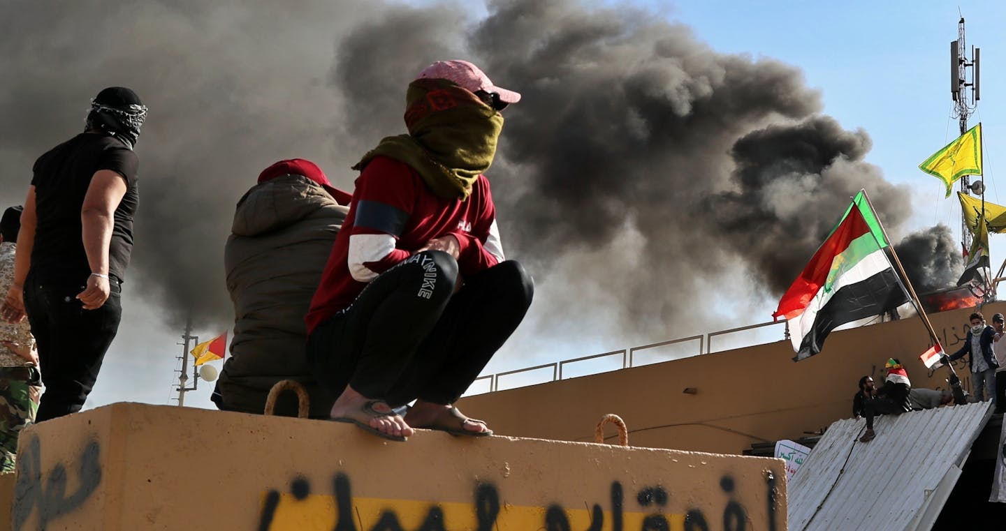 Pro-Iranian militiamen and their supporters set a fire during a sit-in in front of the U.S. embassy in Baghdad, Iraq, Wednesday, Jan. 1, 2020. U.S. troops have fired tear gas to disperse hundreds of pro-Iran militiamen and other protesters who were gathered for a second day outside the American Embassy compound in Baghdad. (AP Photo/Khalid Mohammed)