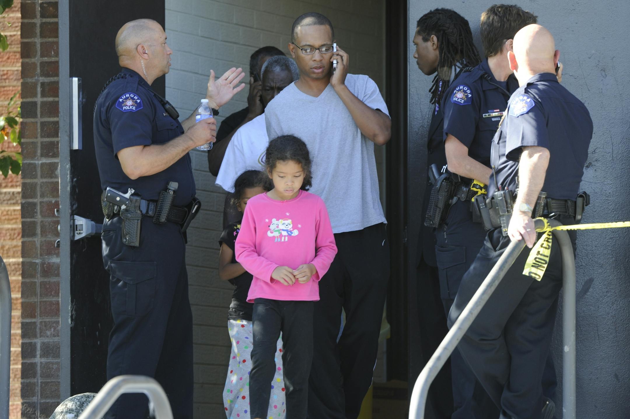 Ian Legins and his children leave Gateway High School in Aurora, Colo, where witnesses we being interviewed by authorities Friday, July 20,2012. A gunman wearing a gas mask set off an unknown gas and fired into the crowded movie theater killing 12 people and injuring at least 50 others, authorities said.