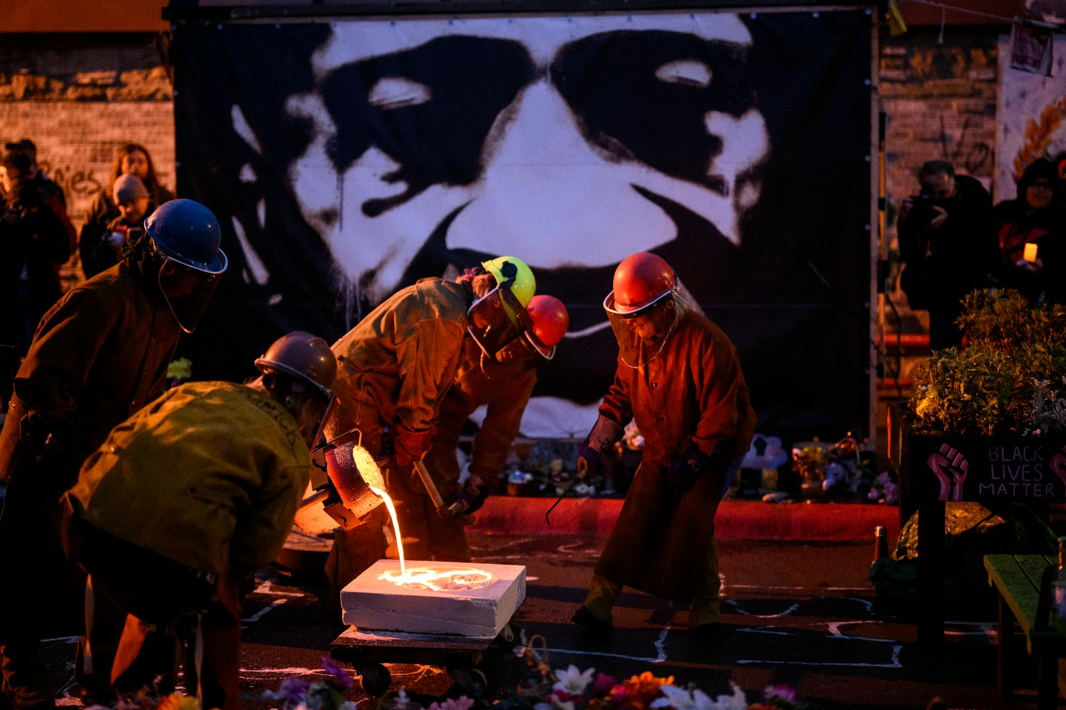 Metal workers with the Chicago Avenue Fire Arts Center and caretaker Mileesha Smith pour a bronze sculpture of a 'Sankofa' symbol.