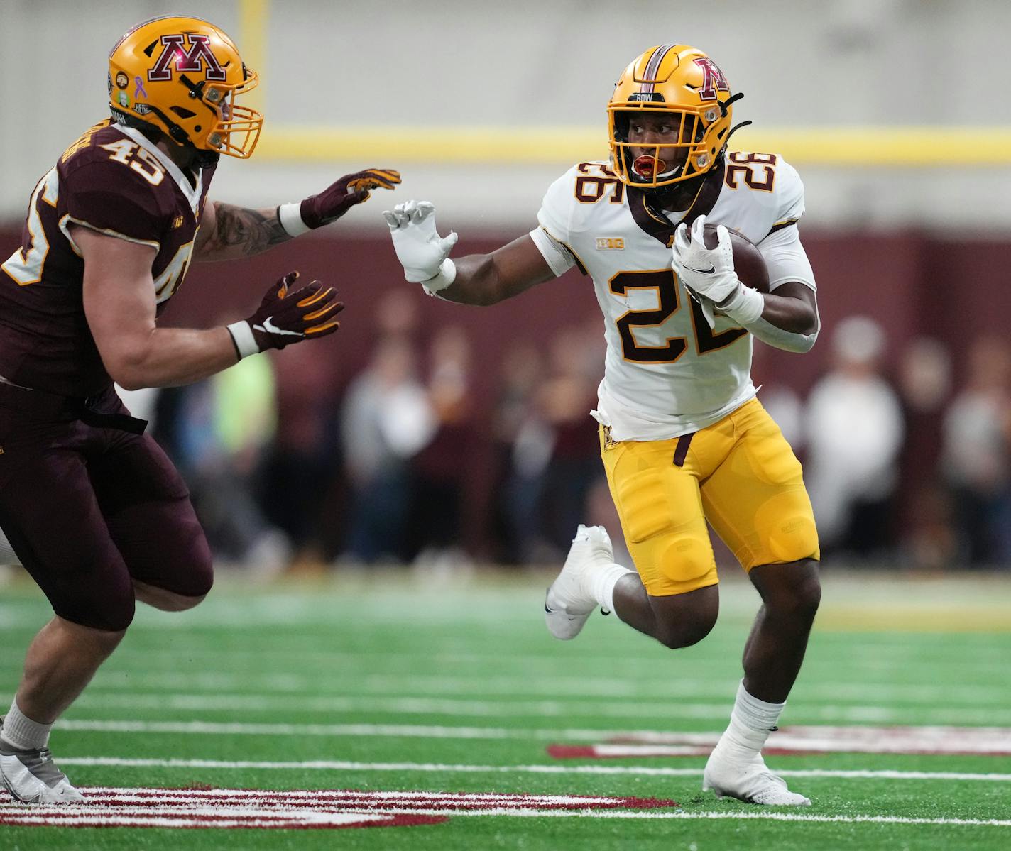 Minnesota running back Zach Evans (26) rushes the ball as linebacker Cody Lindenberg (45) looks to make the stop during the annual Spring Game Saturday, April 30, 2022 in the team's indoor football facility at Athletes Village on the University grounds in Minneapolis. ] ANTHONY SOUFFLE • anthony.souffle@startribune.com