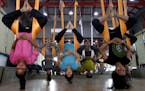 In this Thursday, June 18, 2015, photo, Indians perform anti gravity aerial yoga in Ahmadabad, India. Yoga has a long history India, reaching back for