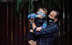 Nicholas Philbrook, right, holds his son Andrew, 4, in his backyard, Wednesday, Nov. 18, 2020, in Camarillo, Calif. Philbrook has been trying to convi