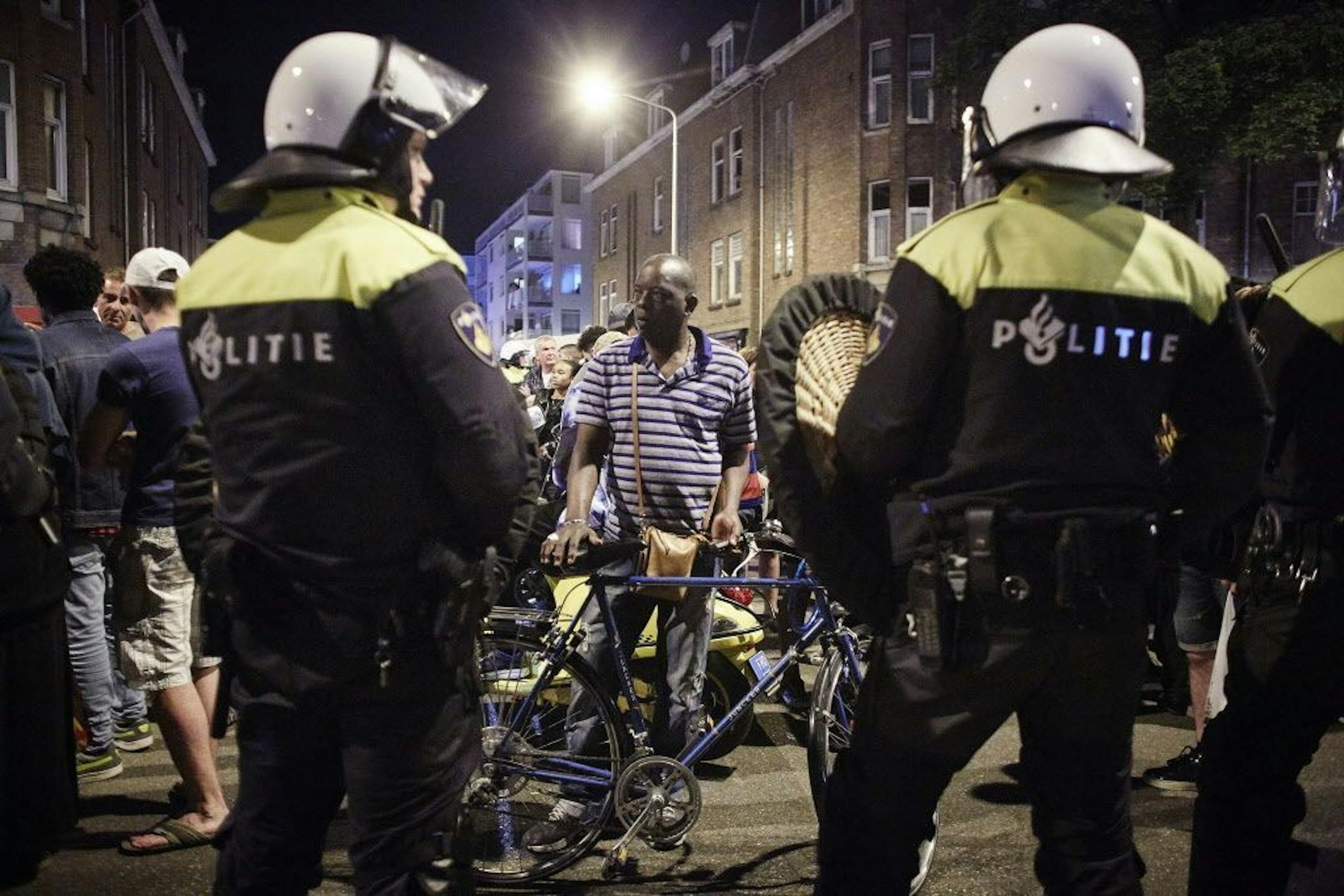 Dutch riot police clash with protesters at Schilderswijk district in The Hague, Netherlands, in the early hours of Friday, July 3, 2015. Dutch police have detained some 200 people for ignoring a ban on public assembly imposed in a neighborhood hit by days of late-night rioting following the death in police custody of a man arrested at a music festival.