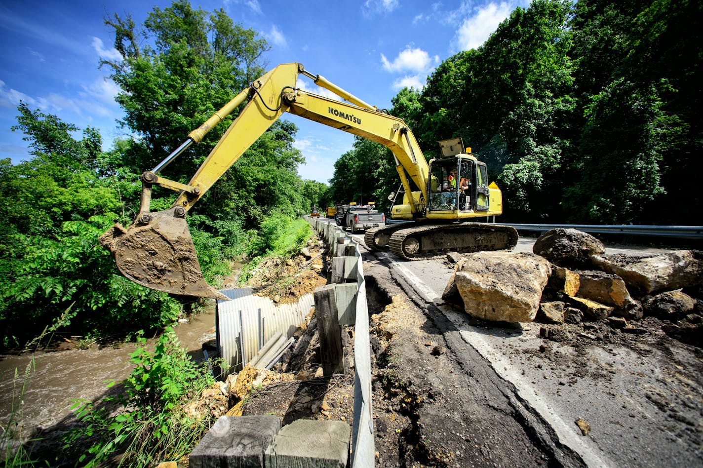 MNDOT crews clear a mudslide and place huge rocks around a washed out culvert along Highway 66, June 18, 2014 in Mankato.