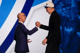 Chet Holmgren, right, is congratulated by NBA Commissioner Adam Silver after being selected second overall in the NBA basketball draft by the Oklahoma
