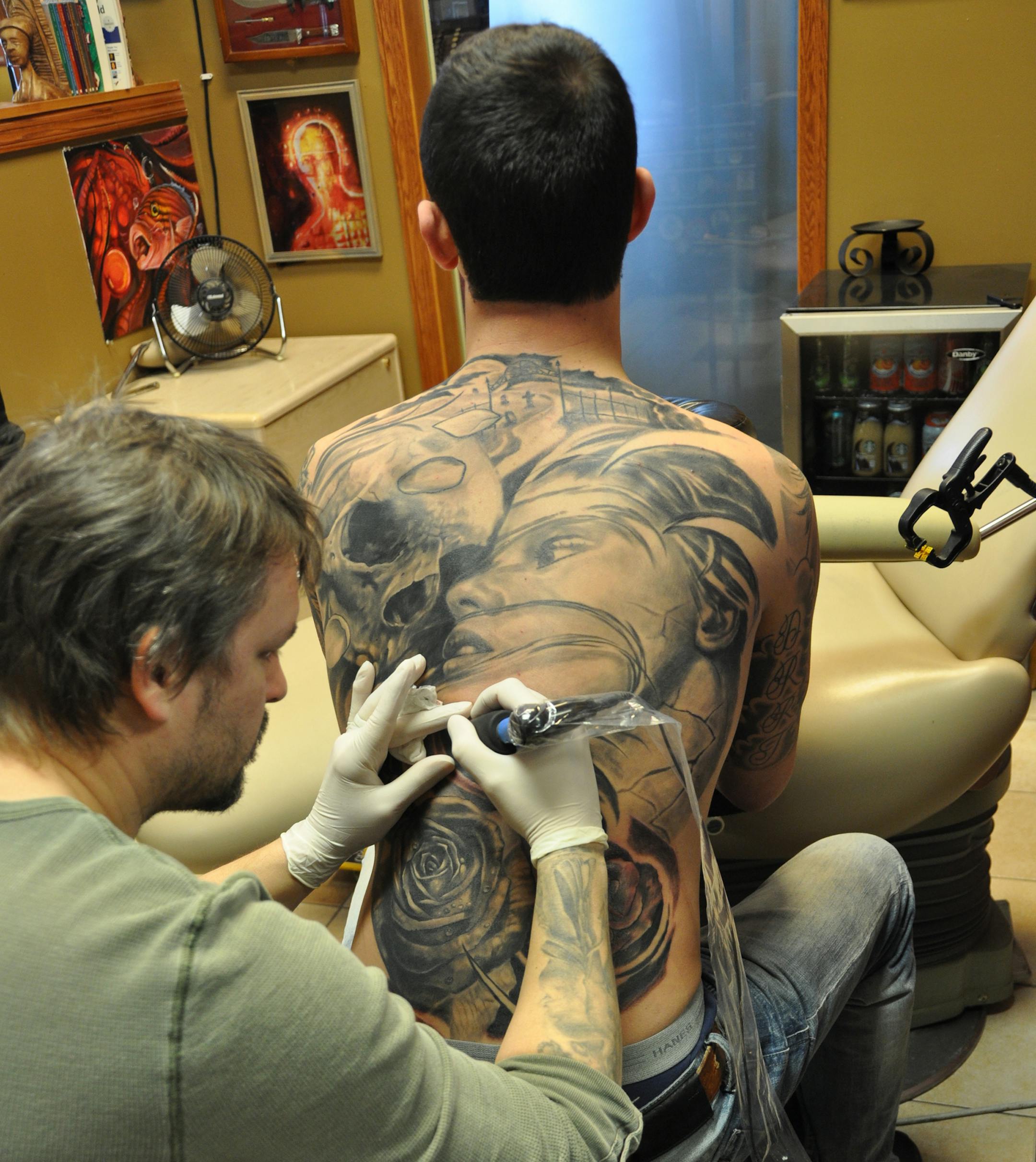 provided photo Tattoo artist Brandon Heffron, owner of Beloved Studios in St. Paul, at work on a client.