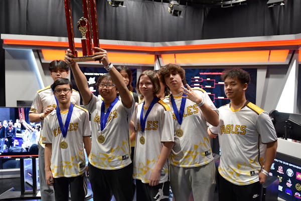 Santiago Lala hefted Apple Valley's e-sports trophy, flanked by his teammates