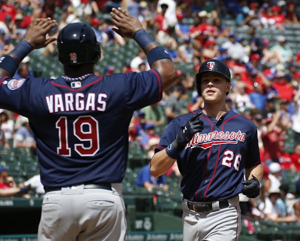 Minnesota Twins' Max Kepler (26) celebrates his grand slam home run as he arrives home with Kennys Vargas against the Texas Rangers during the fifth i