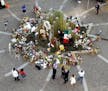 People look at the flowers and items left in tribute to Muhammad Ali at the Muhammad Ali Center Friday, June 10, 2016, in Louisville, Ky.