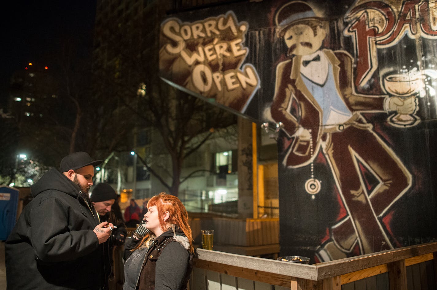 Gonzo Phoenix, left, and Margo Babb smoked outside in the patio area at Palmer's Bar Saturday night before performing with their band, Bricks &amp; Bones. ] (AARON LAVINSKY/STAR TRIBUNE) aaron.lavinsky@startribune.com A profile of Palmer's Bar in West Bank, whose appeal and clientele are a model of coexistence and tradition in the face of trendy cocktail rooms. Photographed Saturday, Dec. 19, 2015 in Minneapolis, Minn.