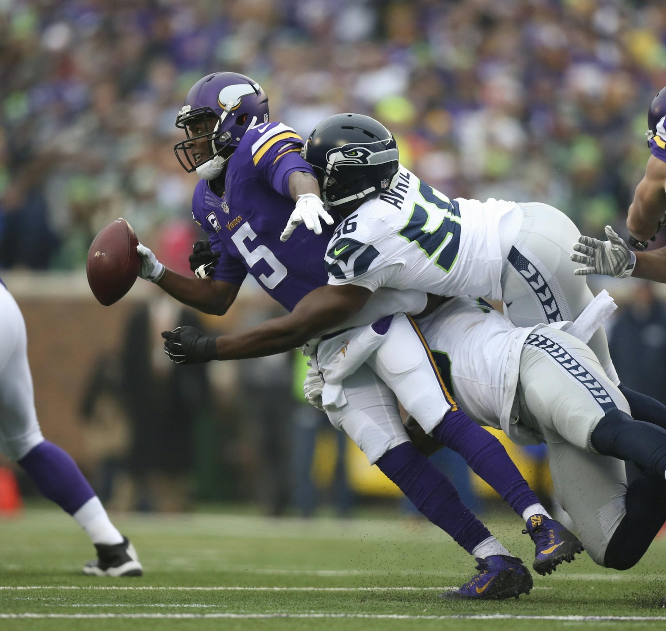 Vikings quarterback Teddy Bridgewater (5) was sacked for a five yard loss in the first quarter Sunday by Seahawks defensive ends Frank Clark (55) and Cliff Avril (56).