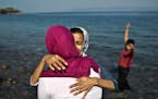 Afghan refugee girls embrace each other shortly after arriving on a dinghy from the Turkish coast to the northeastern Greek island of Lesbos, Sunday, 
