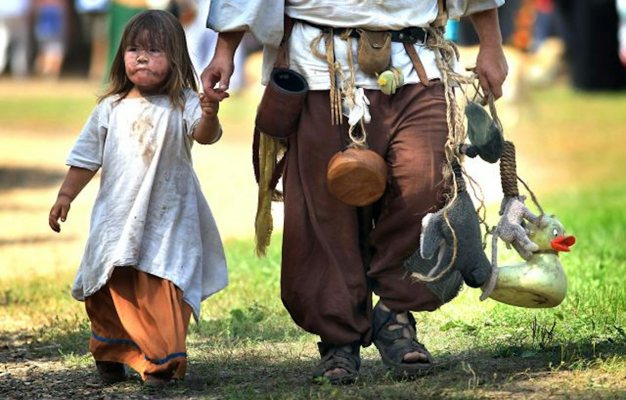 Don Espe, carried some of the tools of his trade as well as toys for his daughter, Ginger, 2 ½, as the pair walked across the Festival grounds. Espe, Apple Valley, said that he works at the King of the Log attraction.