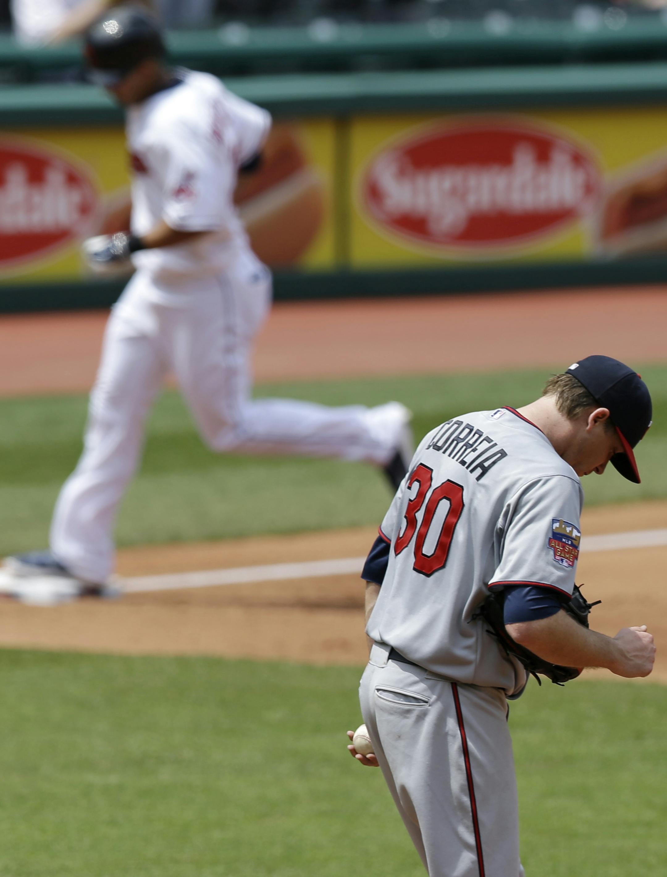 Minnesota Twins starting pitcher Kevin Correia, bottom, waits for Cleveland Indians' Michael Brantley to run the bases after Brantley hit a two-run home run in the fifth inning of a baseball game, Thursday, May 8, 2014, in Cleveland. The Indians won 9-4. (AP Photo/Tony Dejak)