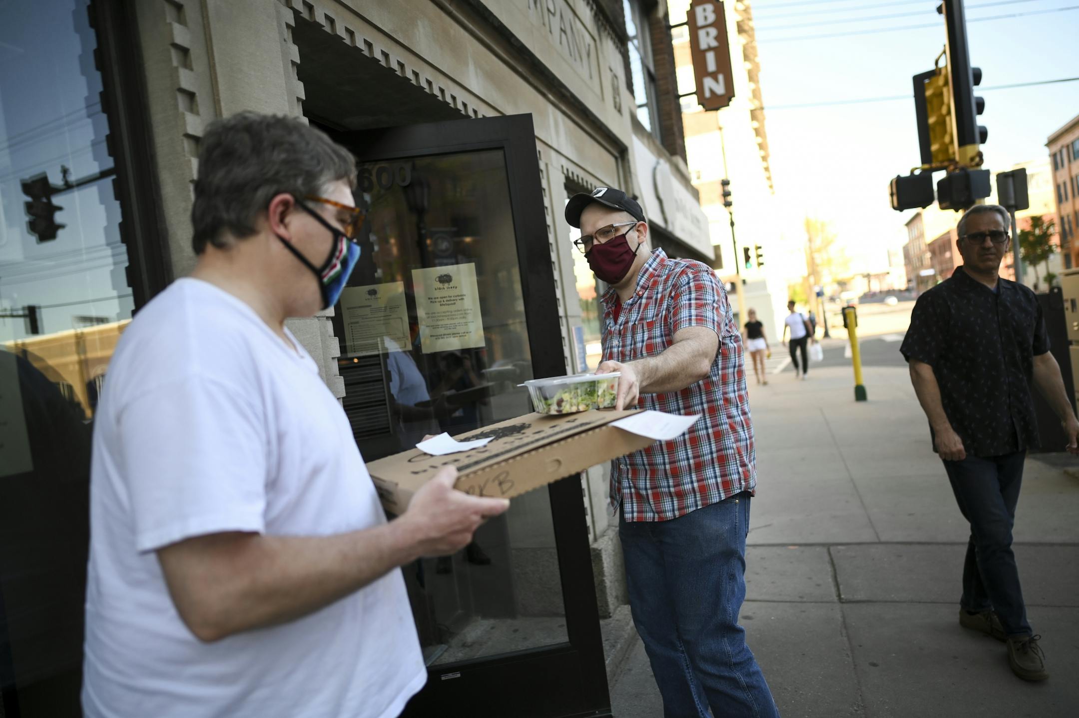 Andrew Schmittfrenz, a manager at Black Sheep's North Loop location, walked outside to deliver an order to Mark Berman Wednesday evening.