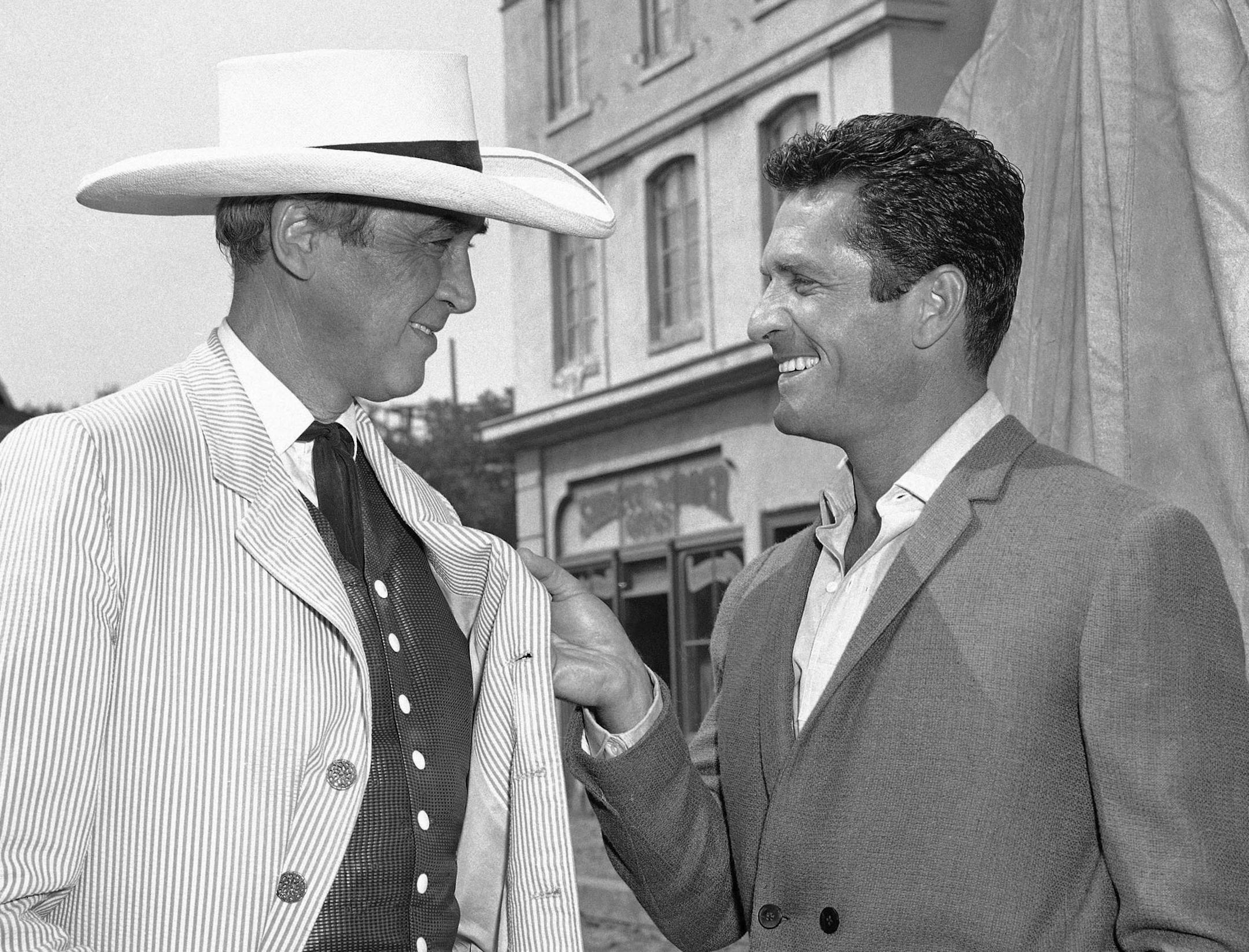 FILE - In this Oct. 24, 1963 file photo, actors James Stewart, left, and Hugh O'Brian confer on the set of "Cheyenne Autumn" in Los Angeles. In the movie, Stewart plays the role of Wyatt Earp, whom O'Brian portrayed on the 1950s television series "The Life and Legend of Wyatt Earp." O'Brian has died at the age of 91. He passed away at this home in Beverly Hills Monday morning, Sept. 5, 2016, according to a statement from HOBY, a youth leadership philanthropic organization that O’Brian fou