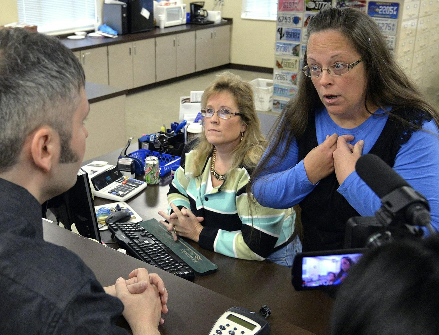 Rowan County Clerk Kim Davis, right, talks with David Moore following her office's refusal to issue marriage licenses at the Rowan County Courthouse in Morehead, Ky., Tuesday, Sept. 1, 2015.