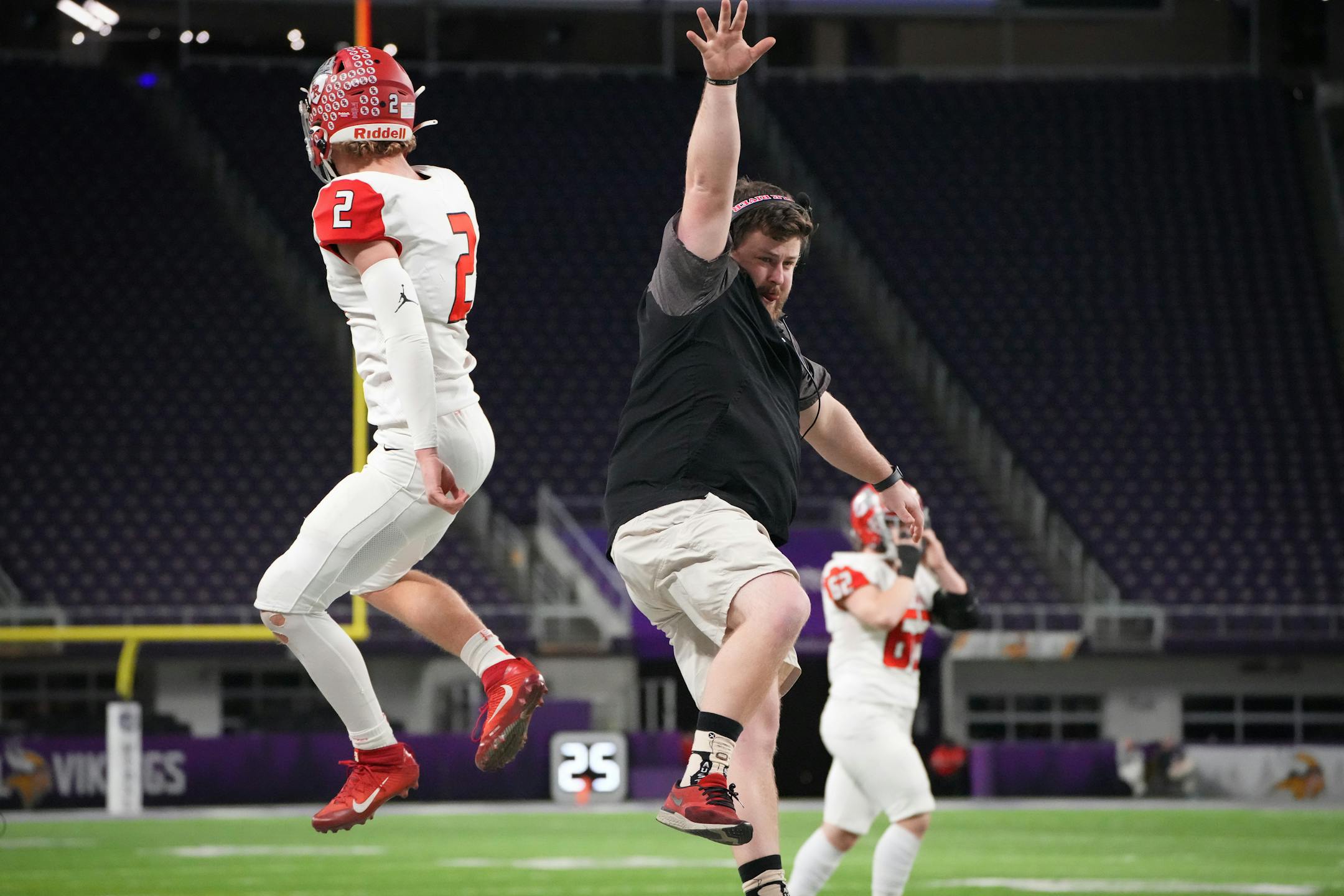Elk River's Cade Osterman (2) celebrates on the sidelines with a coach after scoring a touchdown in the first half of  the Minnesota High School football Class 5A State Championship at U.S. Bank Stadium in Minneapolis, Minn., on Saturday, Dec. 3, 2022.