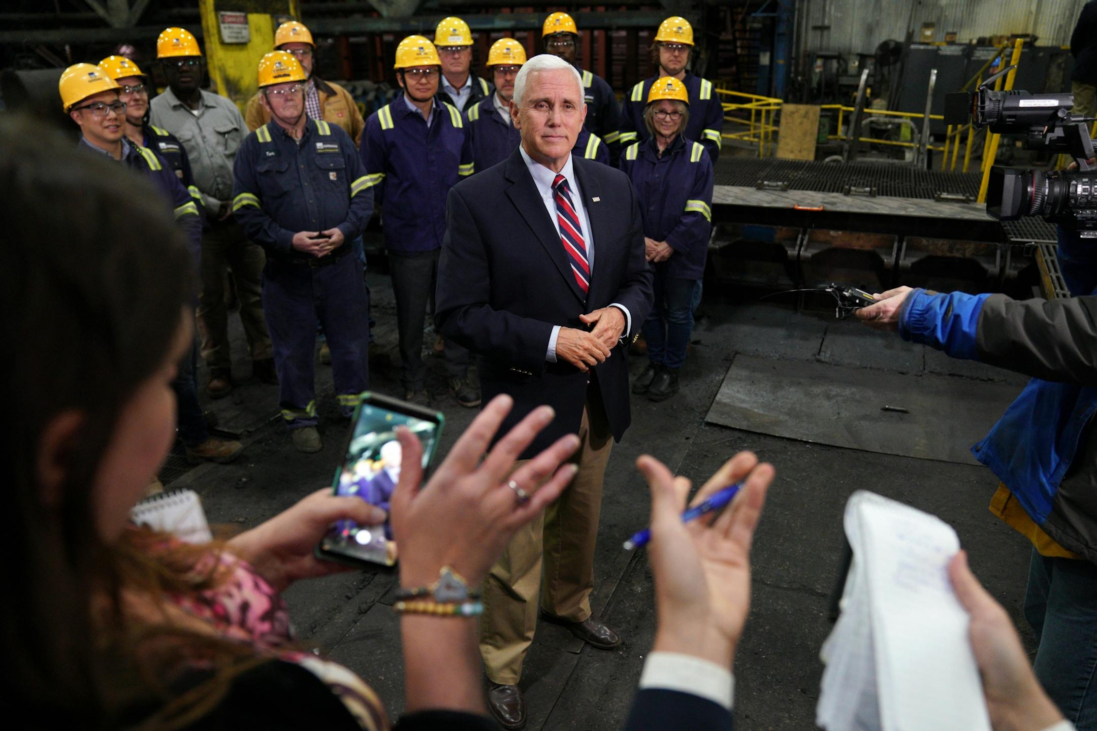 Vice President Mike Pence answered questions from reporters as he stood with a select group of steel workers after giving a speech urging support for President Donald Trump's proposed replacement for the North American Free Trade Agreement at Gerdau Ameristeel Thursday.