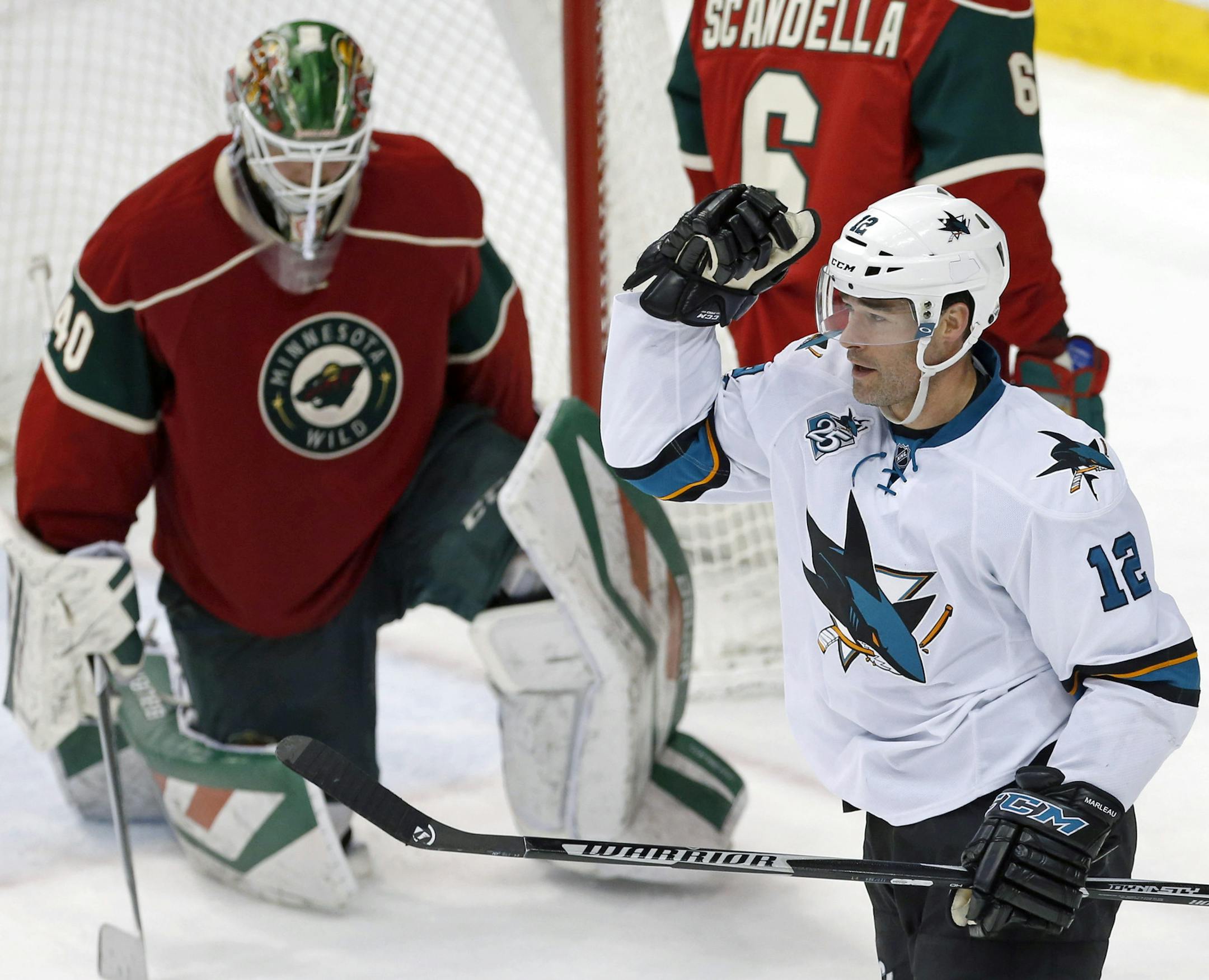 San Jose Sharks' Patrick Marleau, right, celebrates as he scores his second goal of the NHL hockey game against Minnesota Wild goalie Devan Dubnyk in the third period Tuesday, April 5, 2016, in St. Paul, Minn. Marleau scored the other goal in the second period. The Sharks won 3-0. (AP Photo/Jim Mone)
