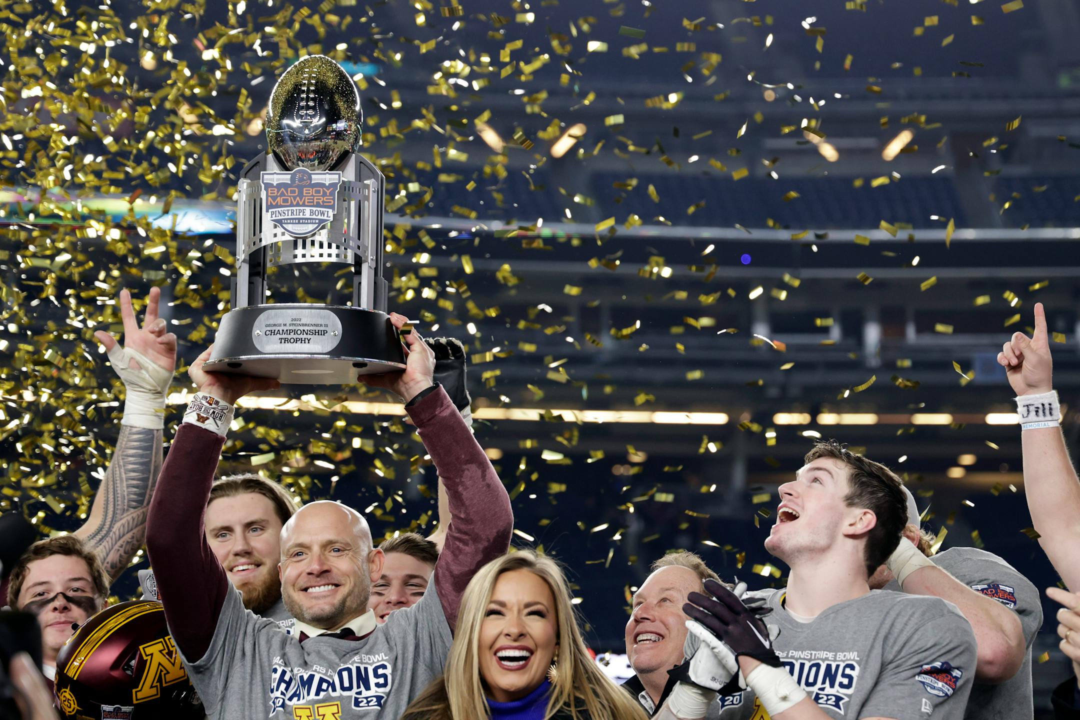 Minnesota head coach P. J. Fleck, front left, celebrates with Coleman Bryson, right, after defeating Syracuse in the Pinstripe Bowl.