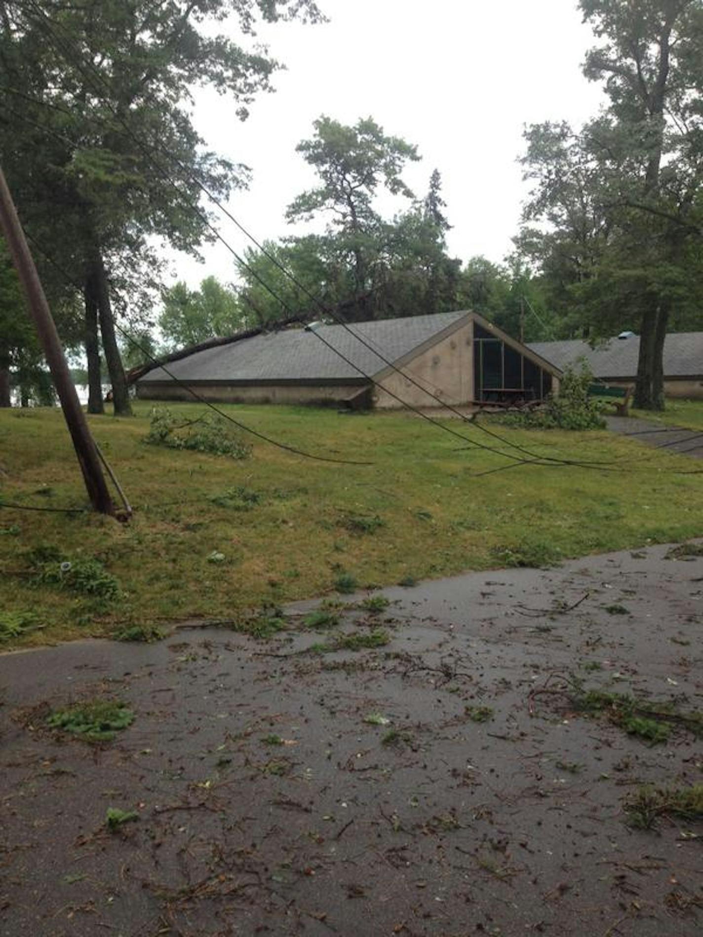 Damage by Legionville Road in Brainerd, Minn. caused by storms last night. The road is blocked by fallen trees around the nearby campground as parents make their way to pick up children from the camp.