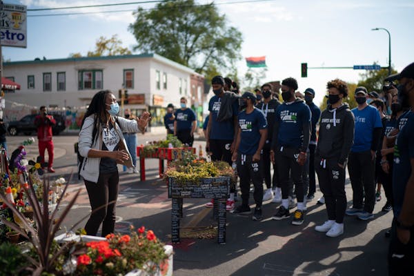 Timberwolves players, coaches, and staffers listened to Jeanelle Austin, left, as she explained and interpreted the memorial site for the group. ] JEF