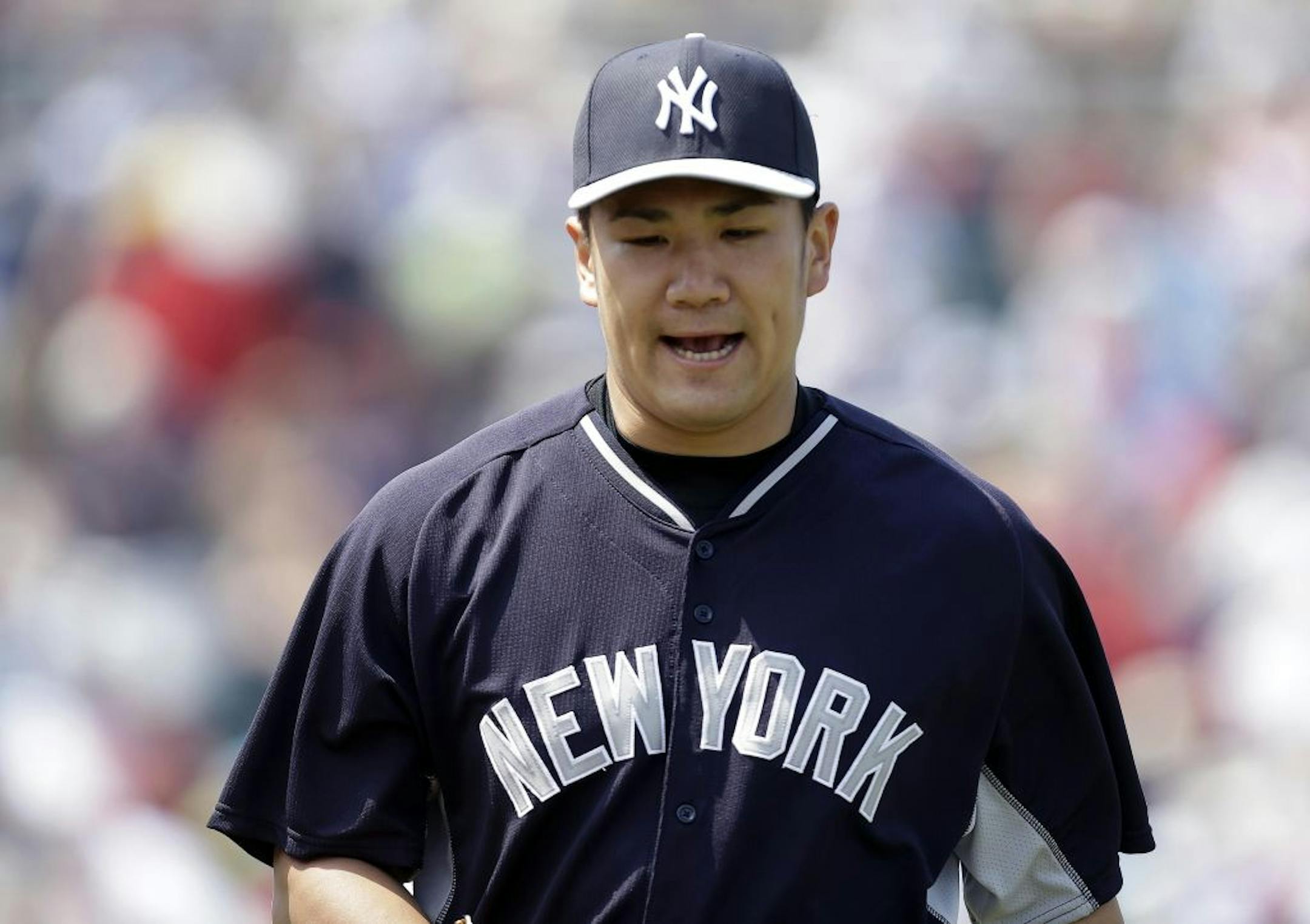 New York Yankees starting pitcher Masahiro Tanaka reacts as he walks off the mound at the end of the third innings of an exhibition baseball game against the Minnesota Twins in Fort Myers, Fla., Saturday, March 22, 2014.