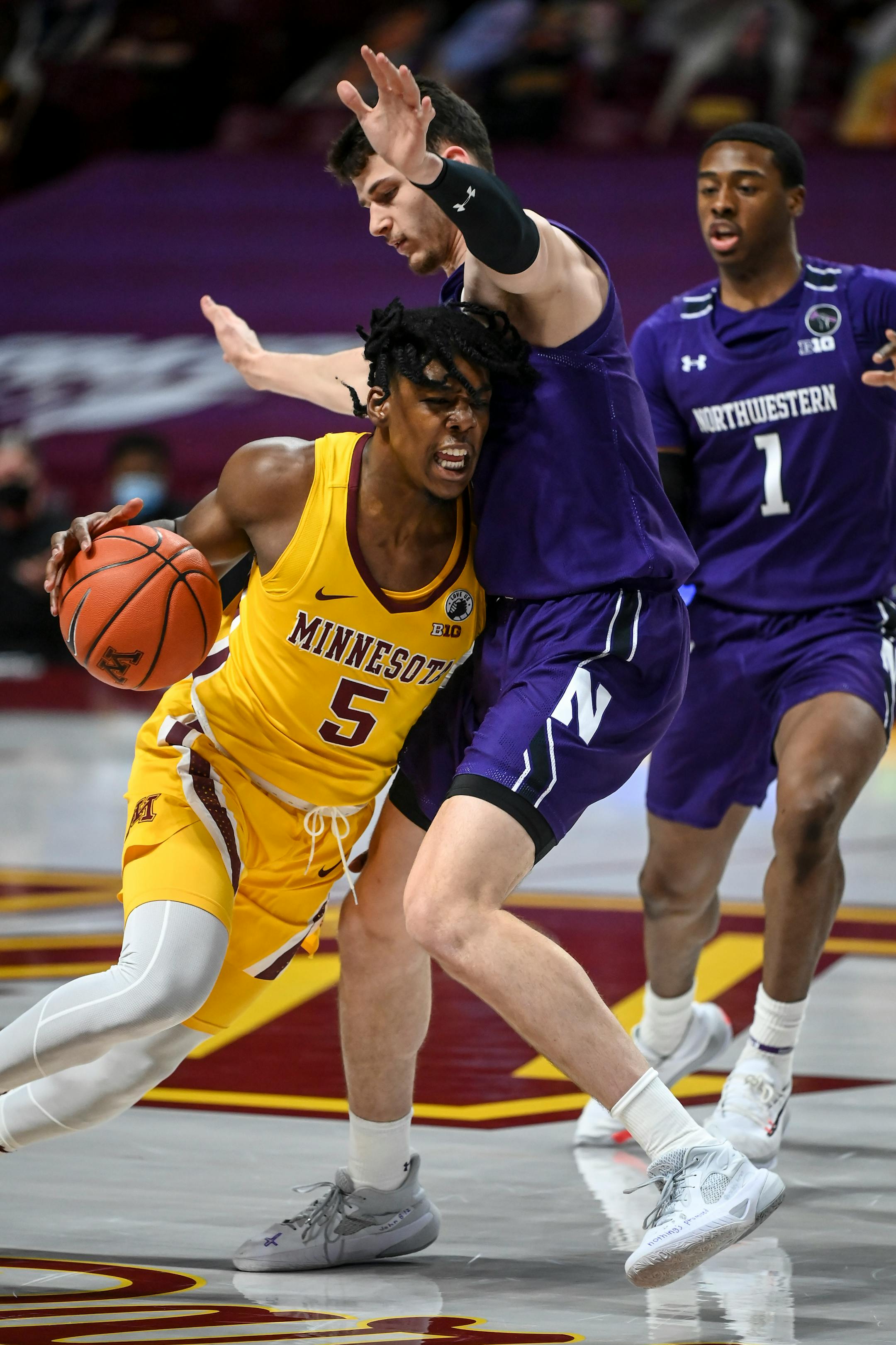 Minnesota Gophers guard Marcus Carr (5) collided with Northwestern Wildcats forward Robbie Beran (31) as he charged toward the basket in the first half.