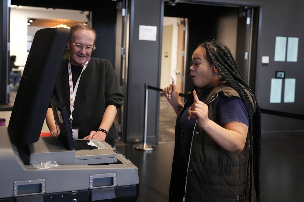 Brittany Collier smiles as she submits her ballot on Election Day at the Capri Theater in north Minneapolis.