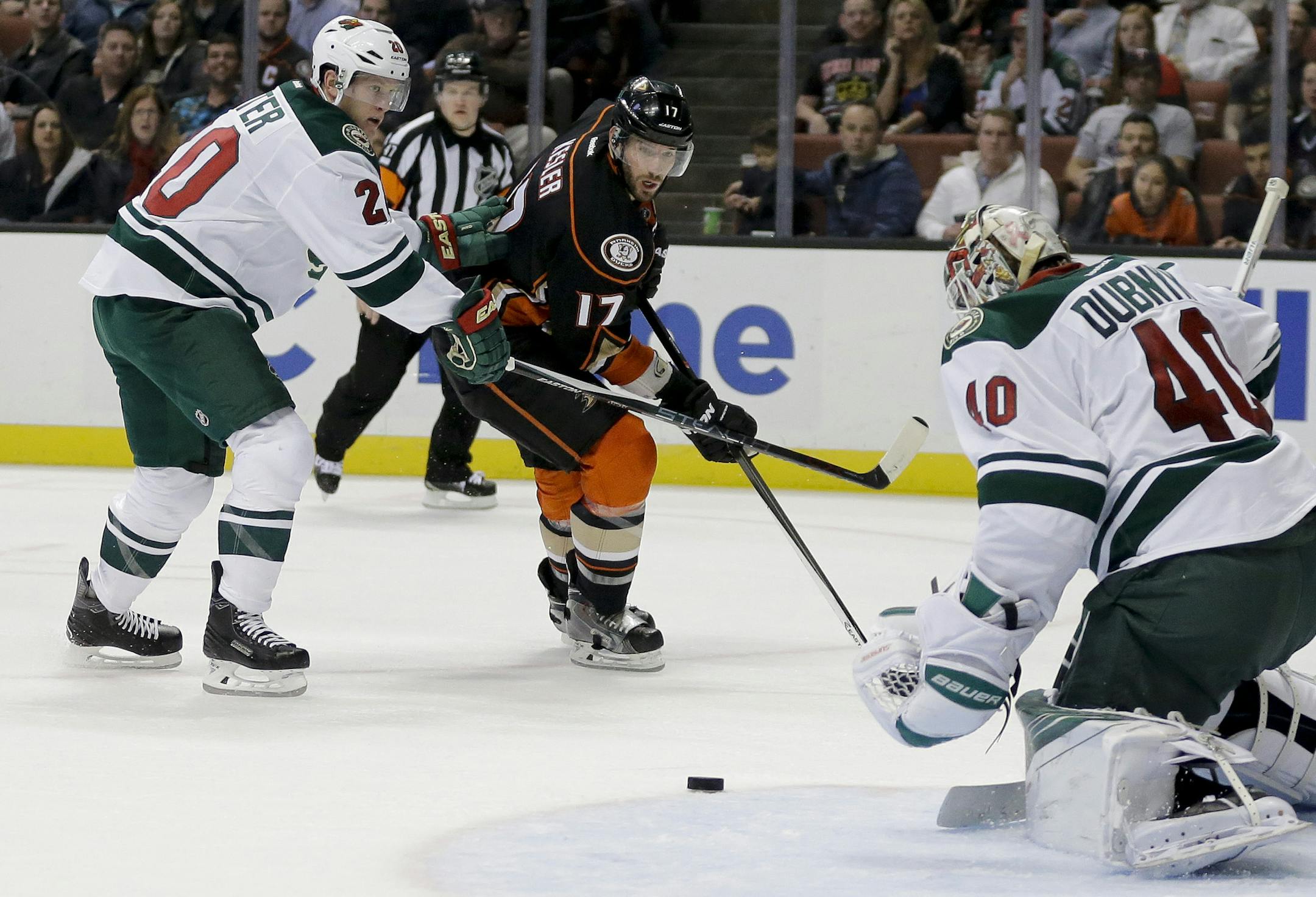 Anaheim Ducks center Ryan Kesler, middle, shoots between Minnesota Wild goalie Devan Dubnyk, right, and defenseman Ryan Suter during the second period of an NHL hockey game in Anaheim, Calif., Wednesday, Jan. 20, 2016. (AP Photo/Chris Carlson)