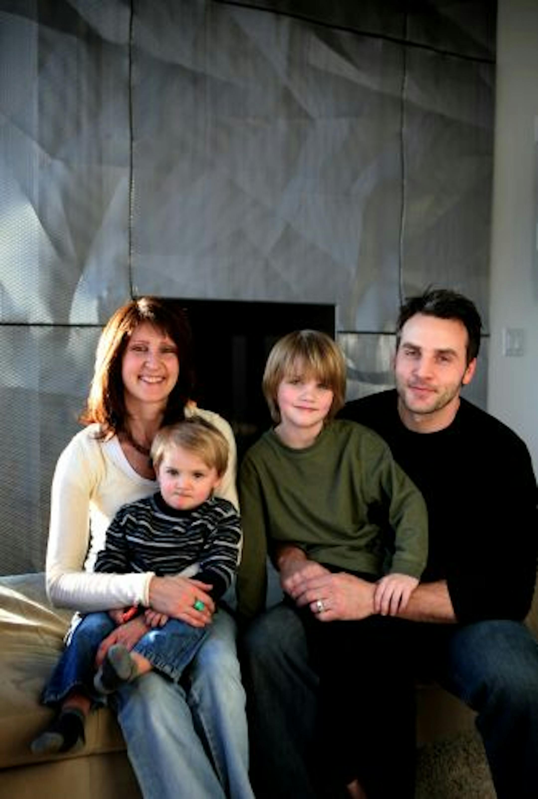 Stacy Bormett, left, and Jason Hammond with their sons Evan, 5, and Aldan, 2, left, in front of their fireplace that was constructed from the same material as the Walker Art Museum.