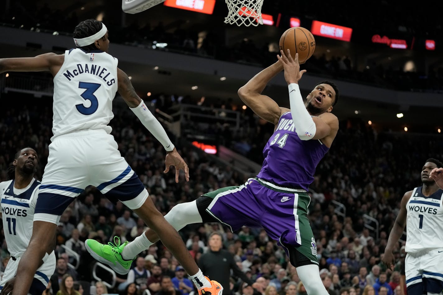 Milwaukee Bucks' Giannis Antetokounmpo looks to pass around Minnesota Timberwolves' Jaden McDaniels during the second half of an NBA basketball game Friday, Dec. 30, 2022, in Milwaukee. The Bucks won 123-114. (AP Photo/Morry Gash)