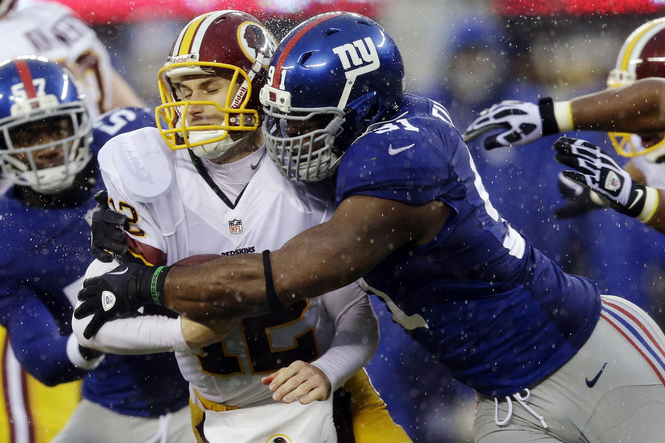 New York Giants defensive end Justin Tuck (91) sacks Washington Redskins' Kirk Cousins (12) during the first half of an NFL football game on Sunday, Dec. 29, 2013, in East Rutherford, N.J. (AP Photo/Julio Cortez)