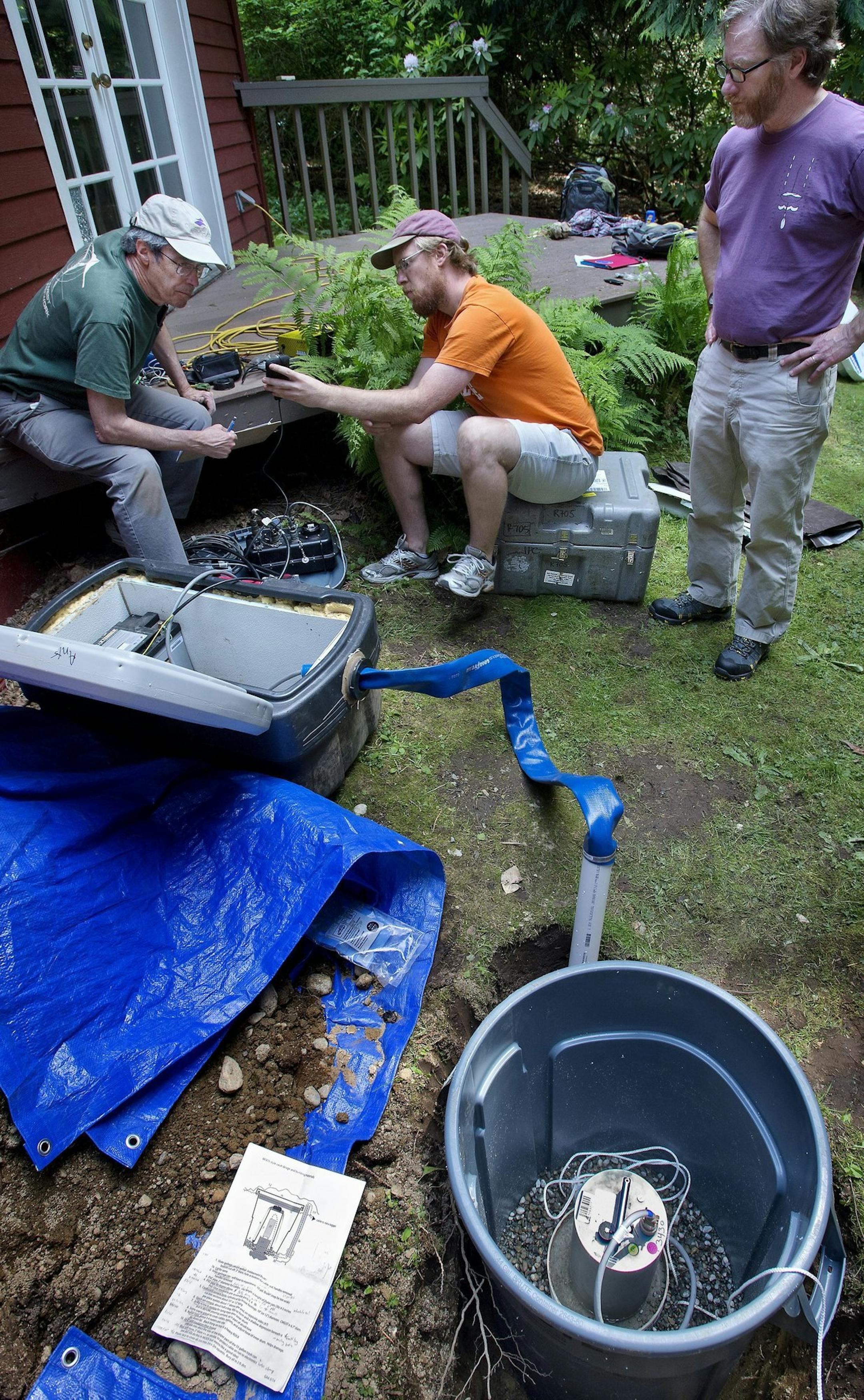 Seismic specialist and UW professor emeritus Steve Malone, left, UW graduate student Carl Ulberg center, and Victor Kress, of the Pacific Northwest Seismic Network, assembled and tested a passive seismic station design in Kress's Lake Forest Park home backyard Monday 5/12/14. Up to 70 of the passive sensing arrays will be installed up to thirty miles form Mount St. Helen's this spring and summer as part of a battery of multidisciplinary imaging experiments collectively called iMUSH for Imaging m