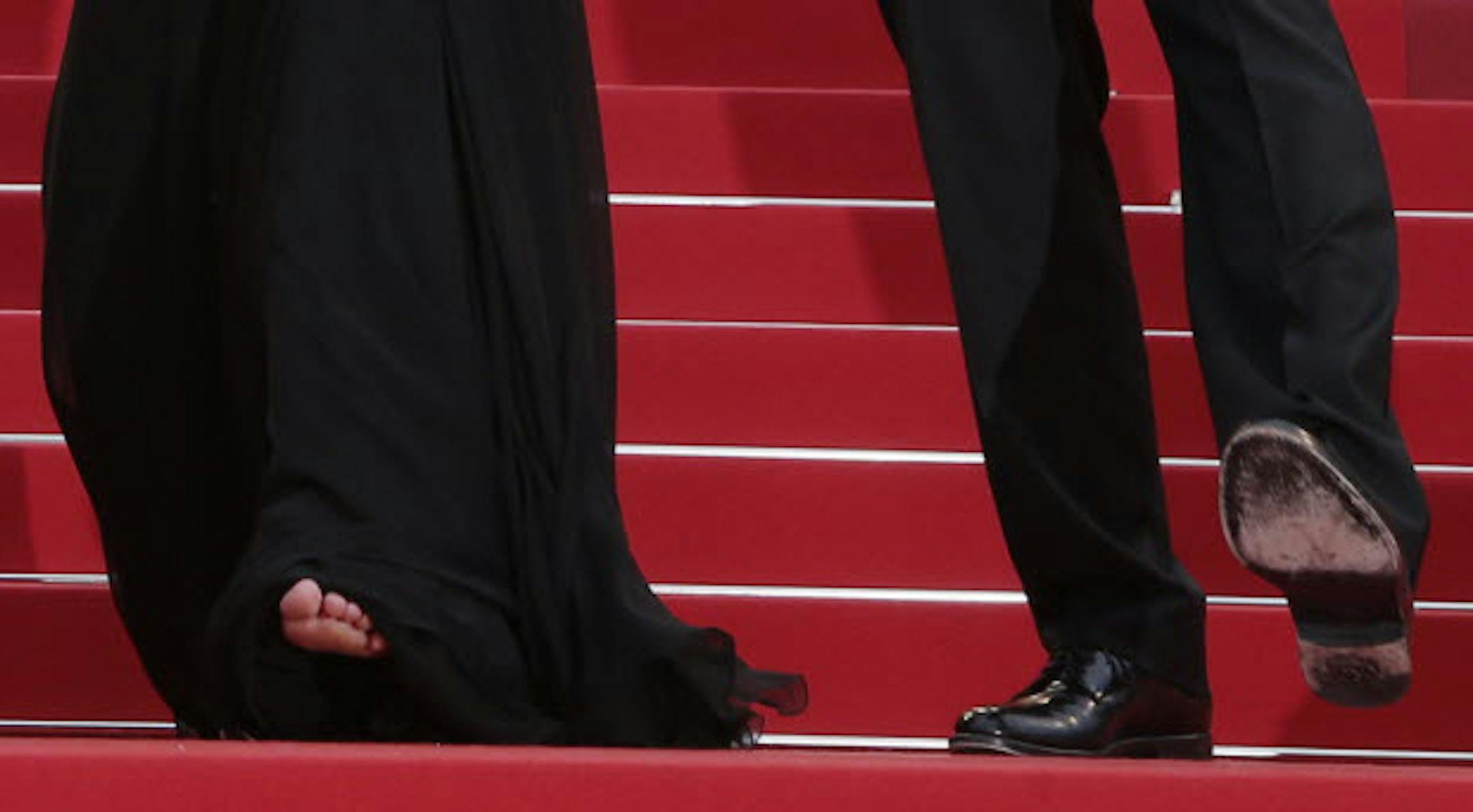 Julia Roberts paused as she ascended the red carpet steps at the Cannes Film Festival to show off her footwear -- or lack thereof. The shoes belong to co-star George Clooney.
