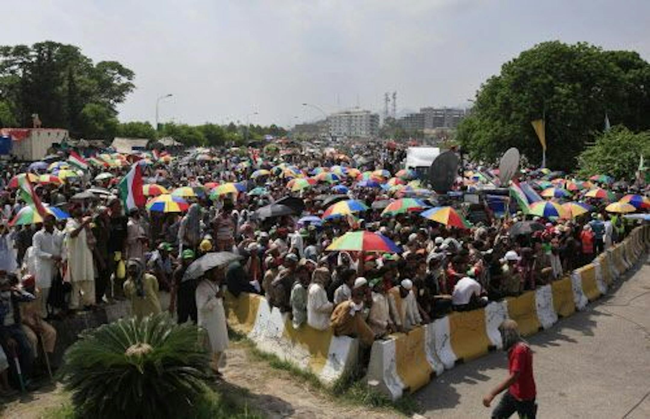 Supporters of anti-government cleric Tahir-ul-Qadri, block an entrance of the parliament, seen in background, during a protest at Islamabad's high-security Red Zone in Islamabad, Pakistan, early Wednesday, Aug. 20, 2014.