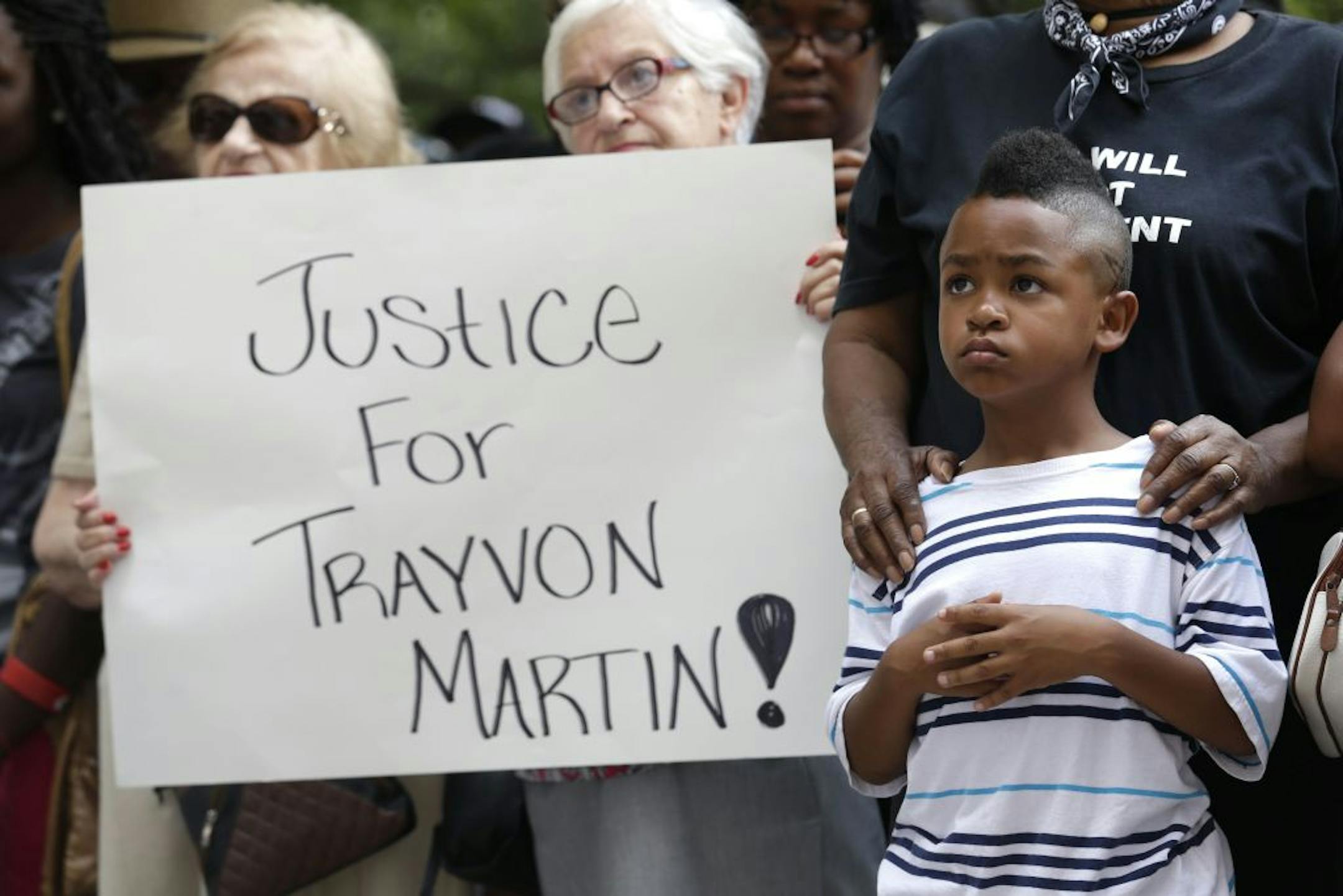 Tommie Butler, 6, stands with his grandmother Sharon Jasper at a rally held in reaction to the recent George Zimmerman acquittal in New Orleans, Saturday, July 20, 2013. The Rev. Al Sharpton's National Action Network organized "Justice for Trayvon" rallies nationwide to press for federal civil rights charges against George Zimmerman, who was found not guilty in the shooting death of unarmed teenager Trayvon Martin.
