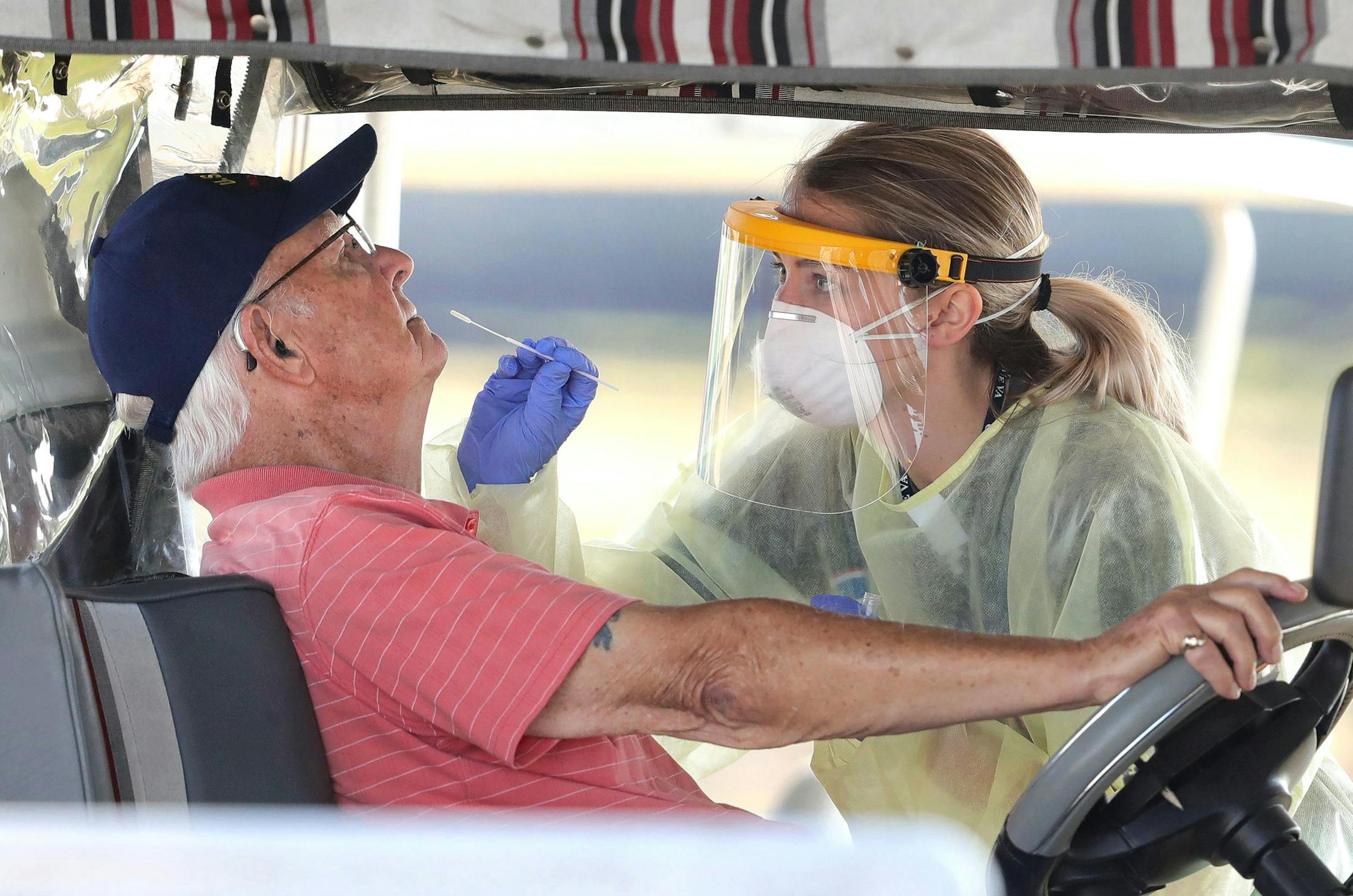 A resident of The Villages, Fla. gets tested for the coronavirus with a nasal swab at a drive-through site that accomodates golf carts, at The Villages Polo Club, Monday, March 23, 2020. The testing site is being operated by UF Health, with University of Florida medical students performing the tests, and is limited to residents of The Villages only. (Joe Burbank/Orlando Sentinel/TNS) ORG XMIT: 1614192